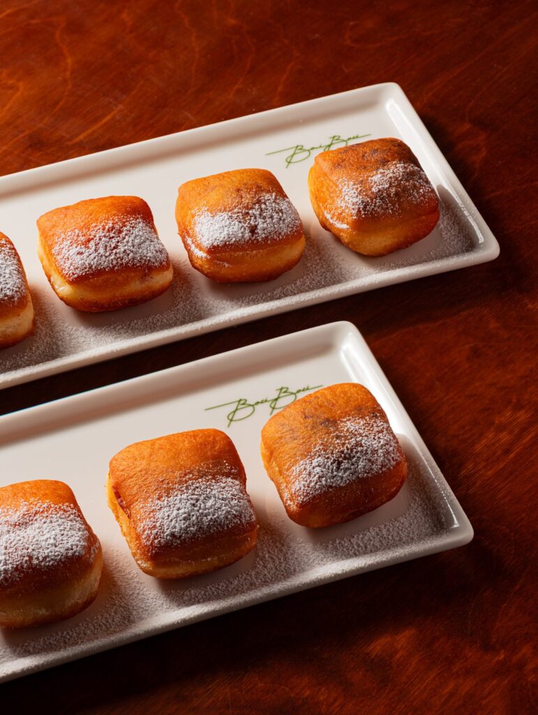 Sugar-dusted bomboloni on a serving plate