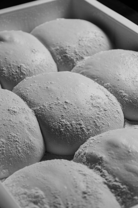 Trays of proved pizza dough balls