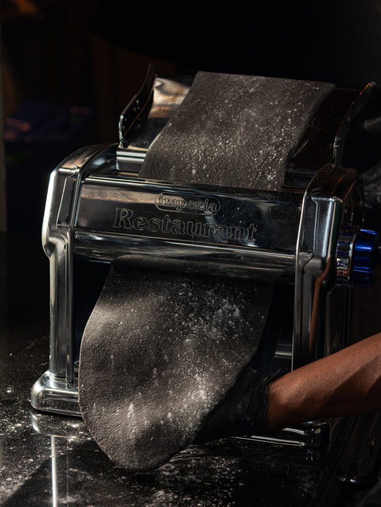 Fresh pasta going through the machine in the kitchen