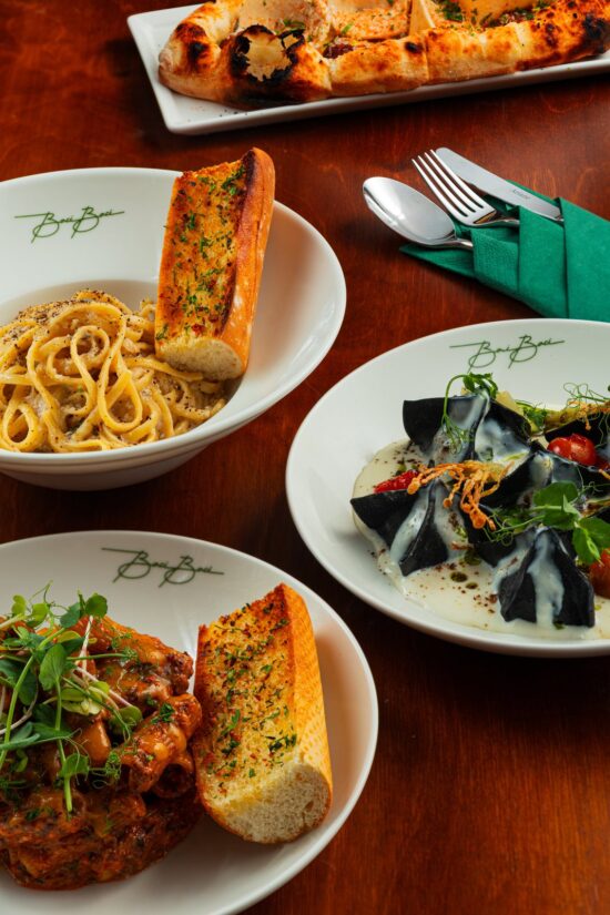 Cacio e pepe, fagottini and pasta al coccio on a table