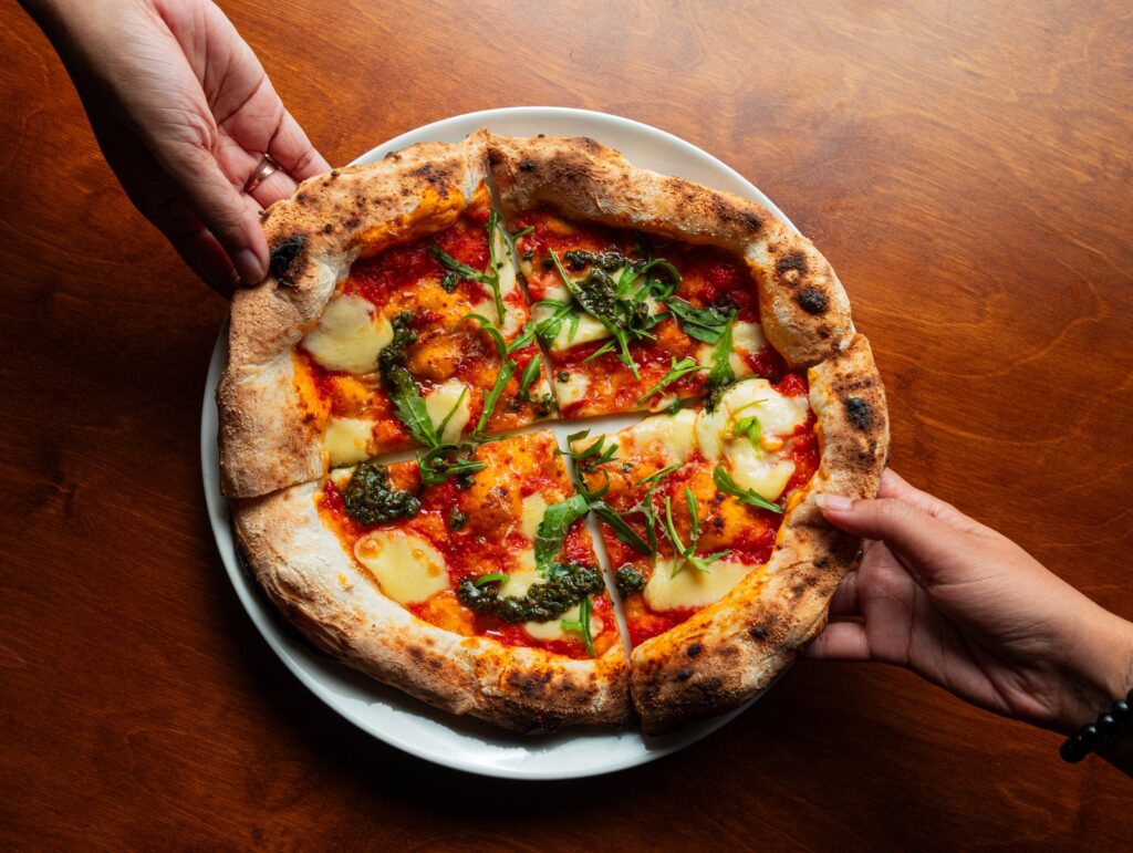 A pizza served with a glass of red wine