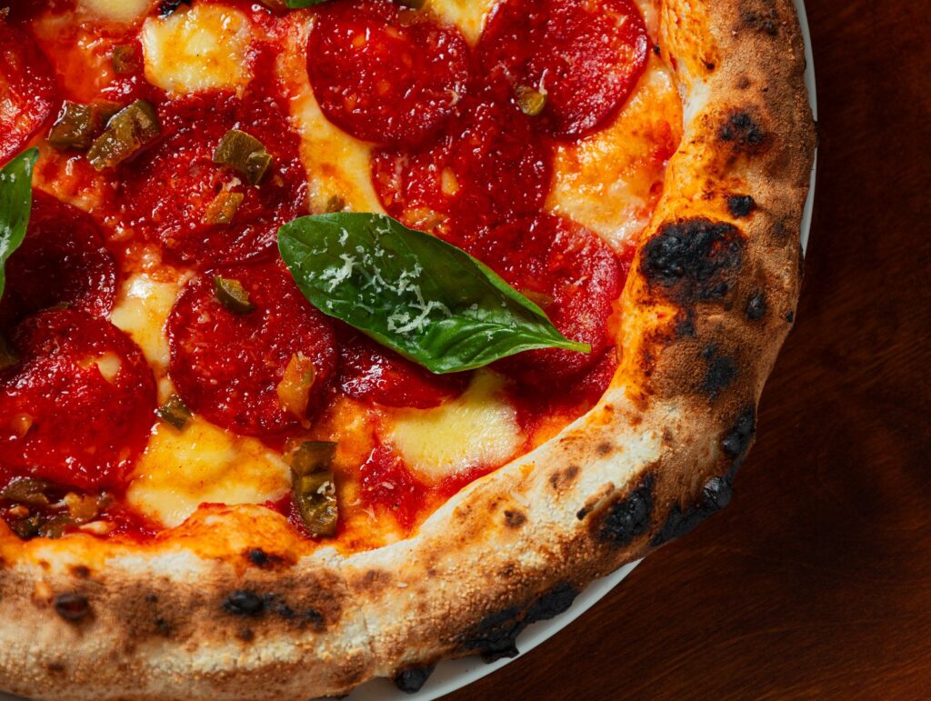 A wood-fired pizza with tomato, mozzarella and basil