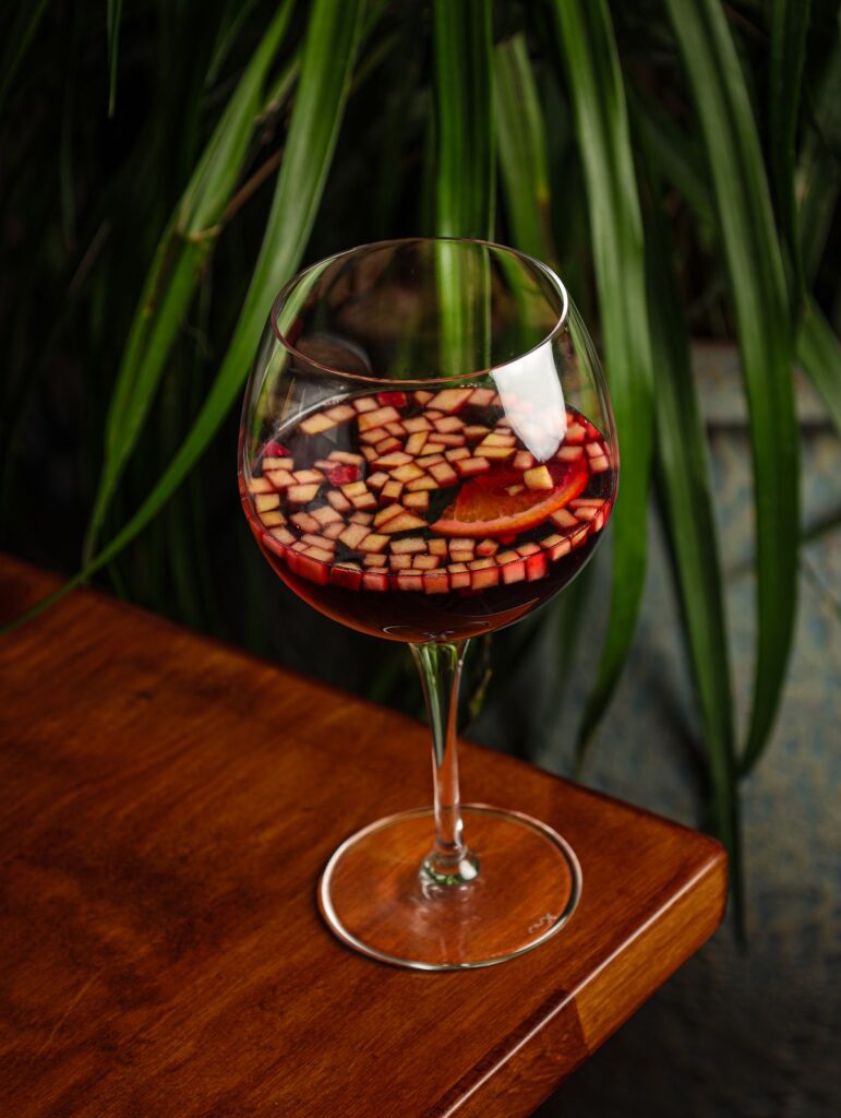 Sangria on a wooden table beside a plant
